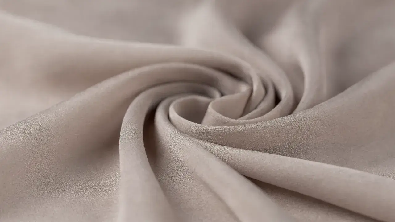 A swirl of soft, beige fabric. This close-up shows the texture and drape of a material, making one wonder, is viscose a good material for flowy garments?