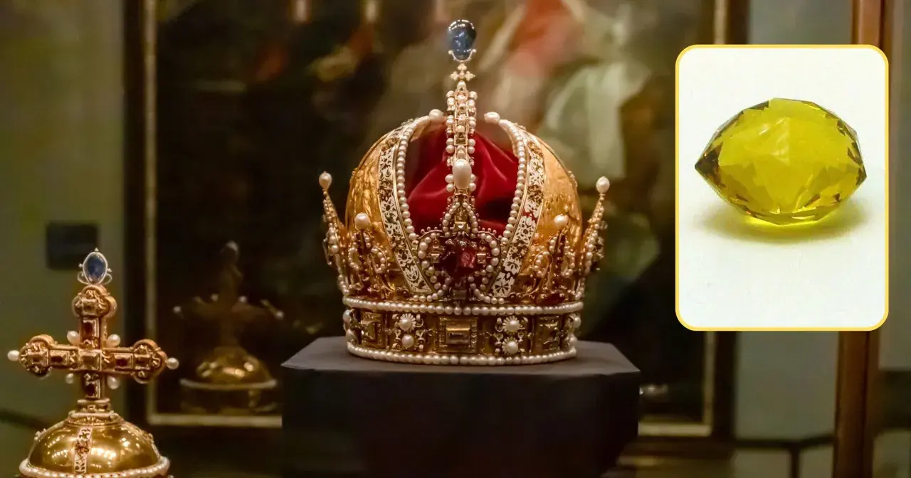 Korona ozdobiona perłami i klejnotami, obok krzyż. W rogu żółty kamień, być może diamenty tekst.