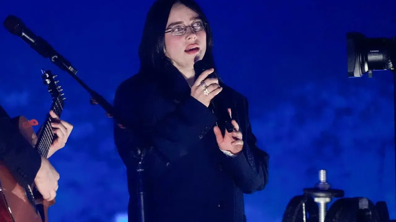 Billie Eilish sjunger på scen i Sverige, med en gitarrist bredvid.