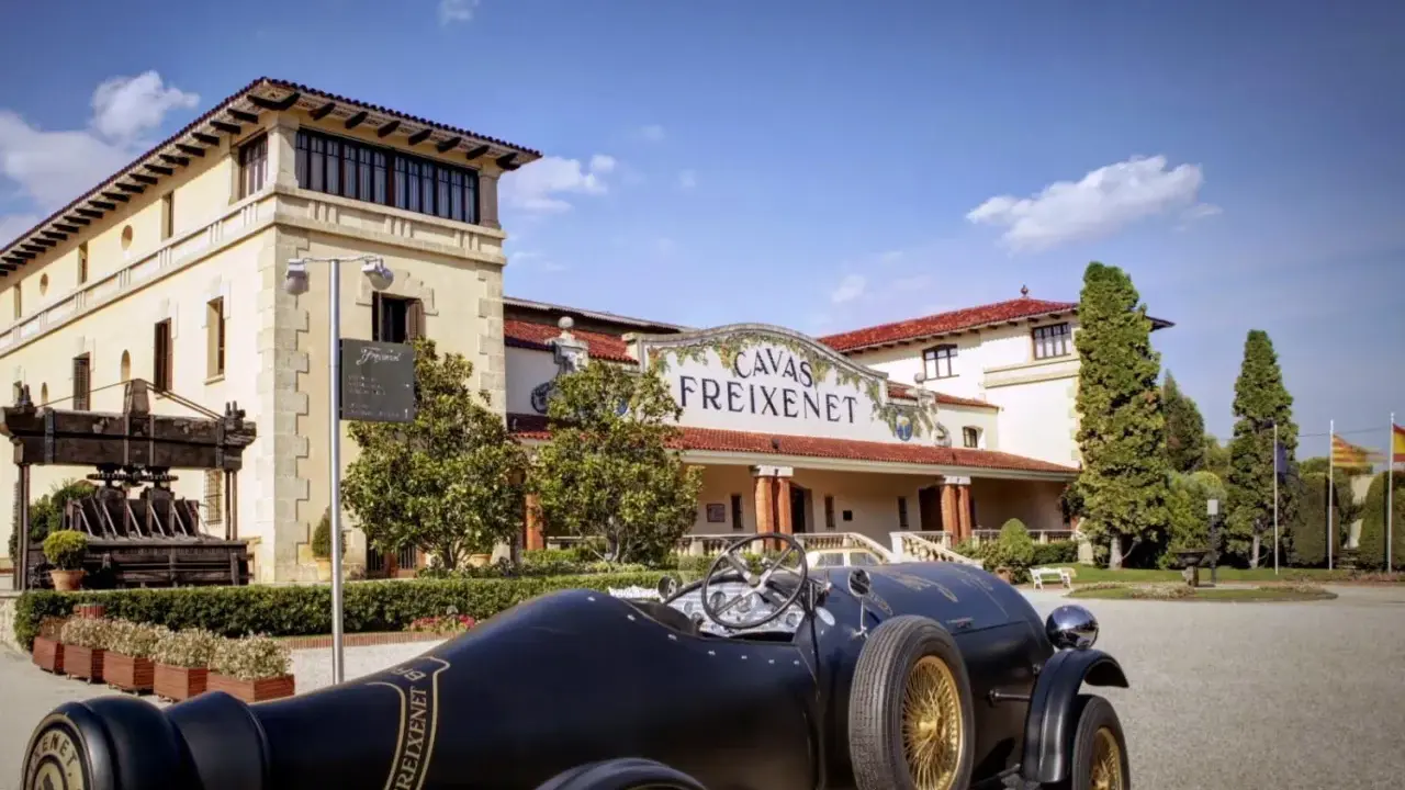 Un coche clásico negro frente a las Cavas Freixenet en Penedès.