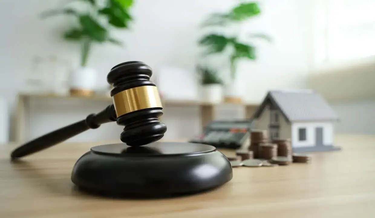 Marteau de juge, maison miniature, calculatrice et pièces. Le virement notaire combien de temps ?