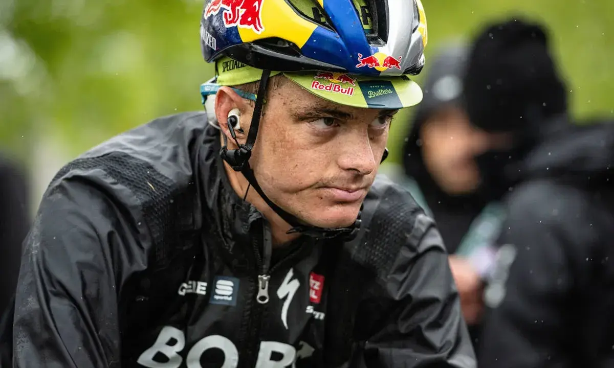 Anton Palzer im Regen, mit Red Bull Helm und BORA-Hansgrohe Jacke.