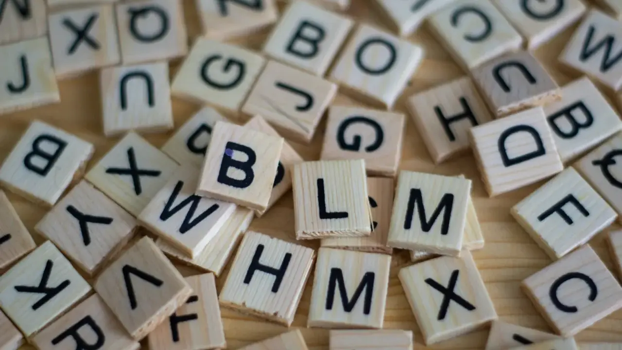 Drewniane klocki z literami, jak w grze Scrabble. Układają się w słowa, może nawet w najdłuższe słowo po angielsku?