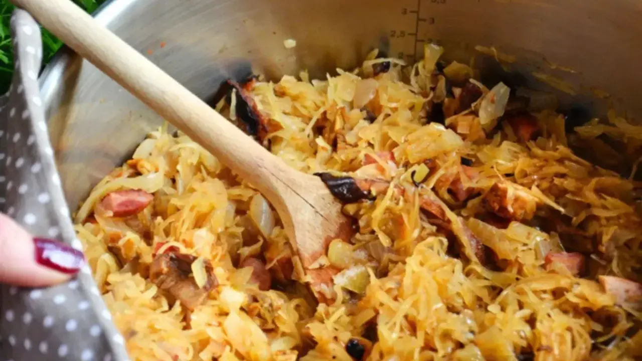 Gotujesz bigos? W garnku widać kapustę kiszoną z różnymi rodzajami mięsa, jak wieprzowina i kiełbasa. Idealne jakie mięso do bigosu!
