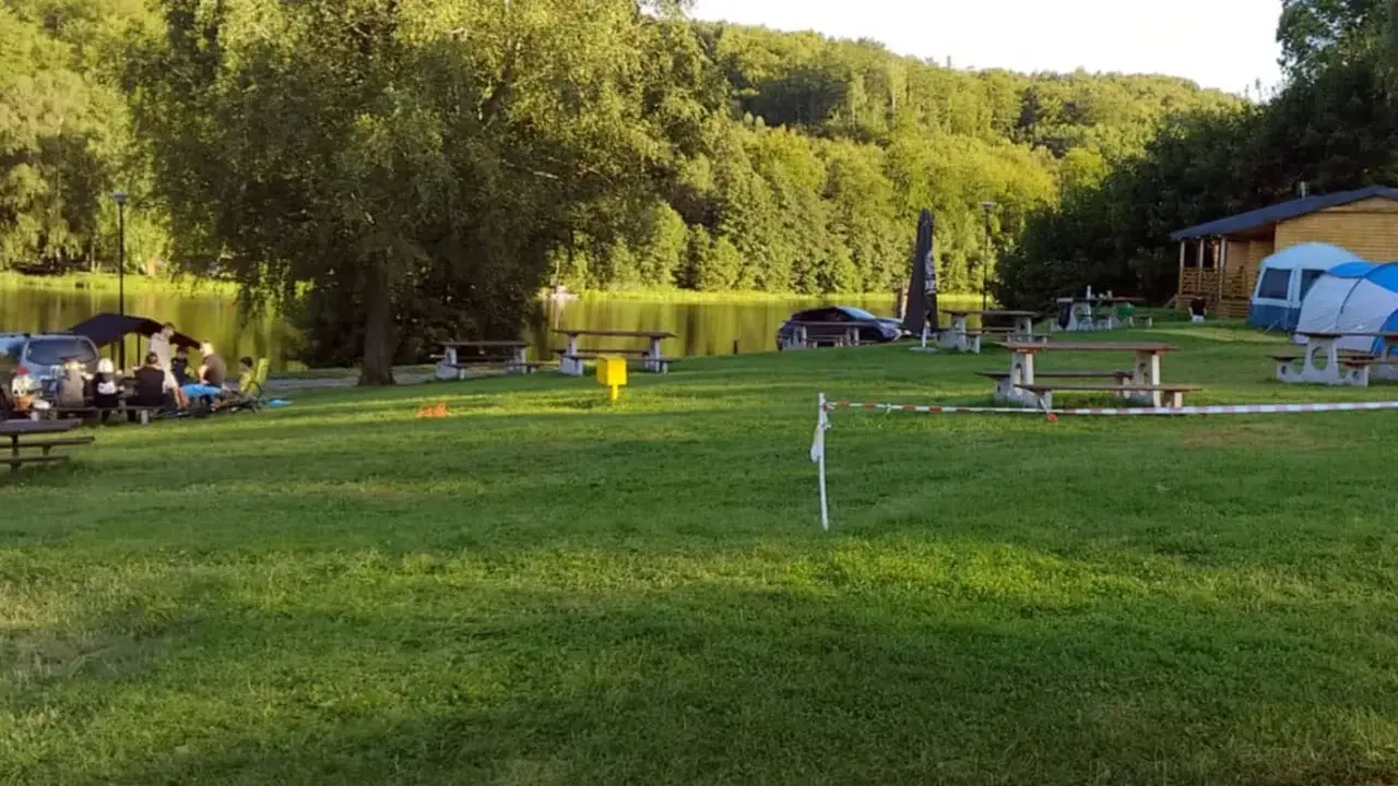 Relaks nad jeziorem, piknikowe stoły i namioty tworzą sielski krajobraz. To miejsce to prawdziwa **mała Szwajcaria Przywidz**.