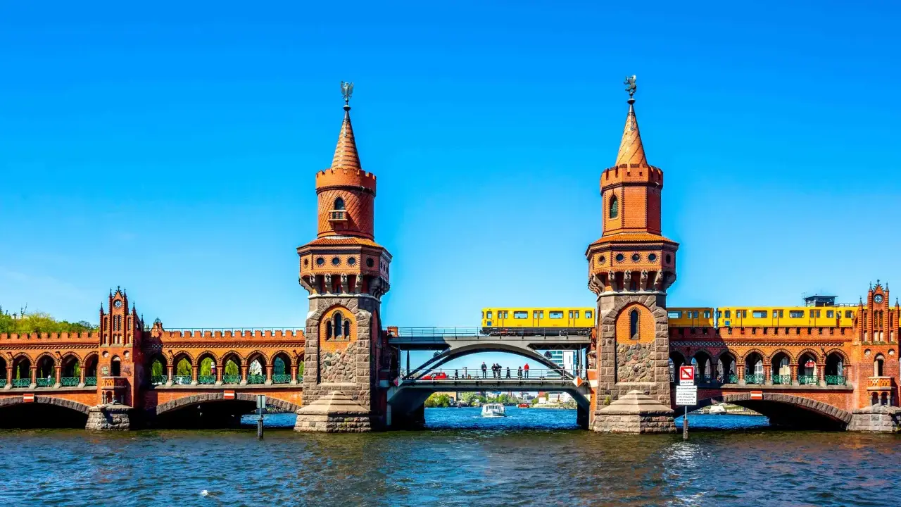 Oberbaumbrücke in Berlin: Ein Muss für jeden Besucher. Eine gelbe U-Bahn fährt über die historische Brücke, die mit ihren Türmchen und Bögen beeindruckt.