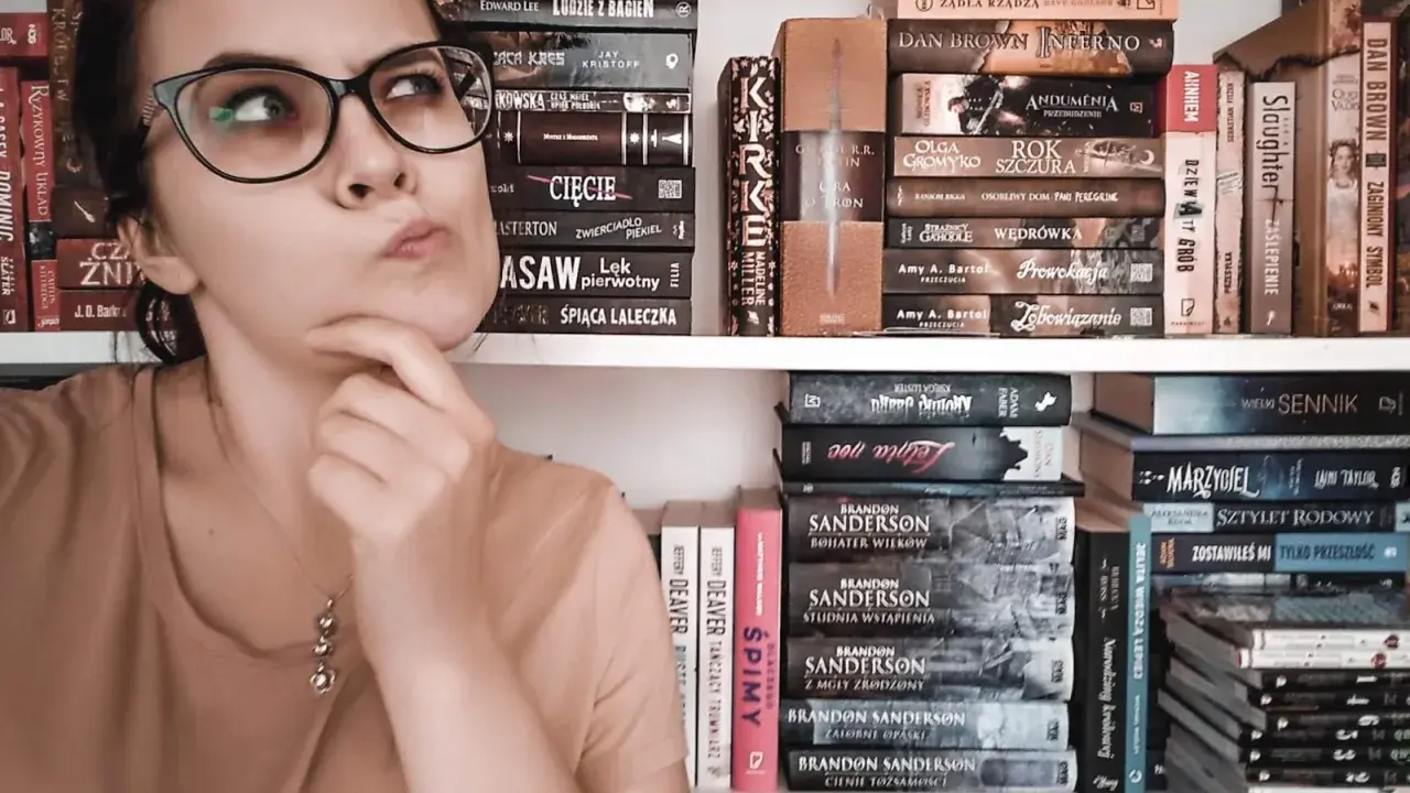 Dziewczyna z okularami zastanawia się nad wyborem książki. Na półkach obok kryminały, fantasy i erotyka subtelna.