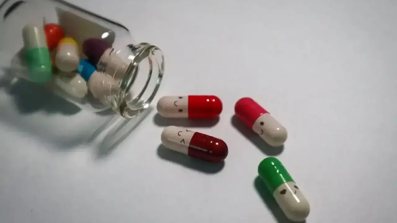 Kapsułki z uśmiechniętymi buźkami, niektóre wypadły z buteleczki. Leki antydepresyjne a wyniki krwi - czy mają wpływ na samopoczucie?