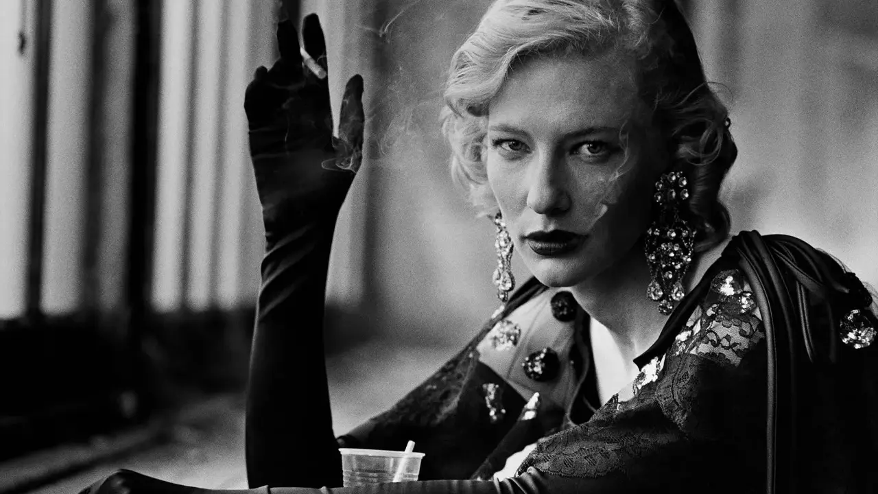 A woman with blonde hair and dramatic earrings smokes, a signature element in many Peter Lindbergh famous photos.