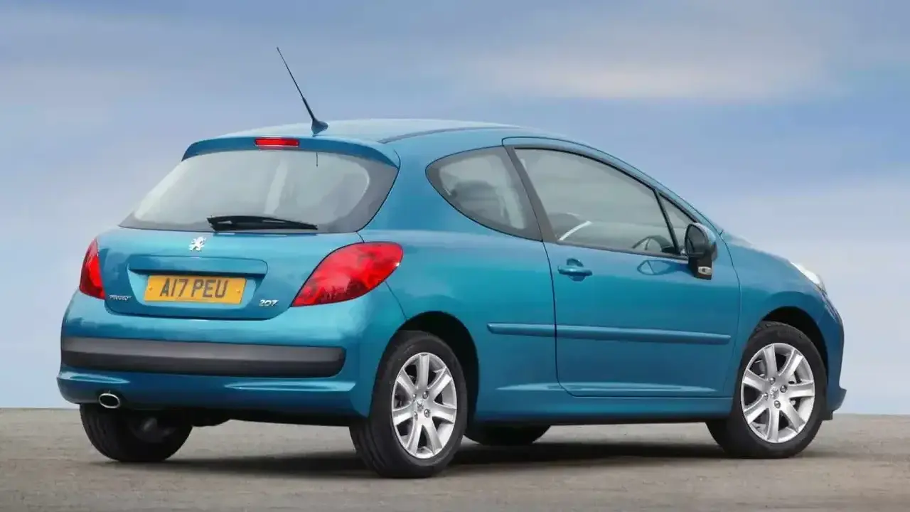 Niebieski Peugeot 207 1.6 HDI z 2007 roku, widok z tyłu, na tle błękitnego nieba.