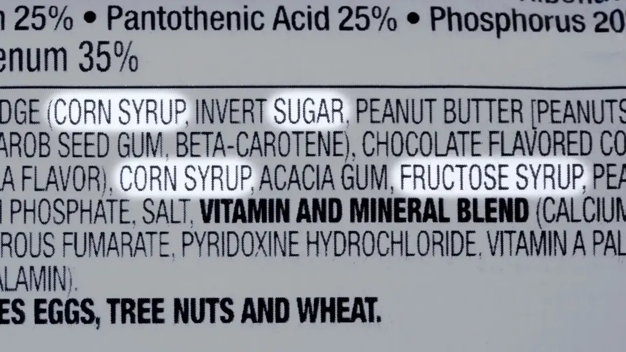 Zutatenliste mit Fruktosesirup, wichtig für Menschen mit Fruktoseintoleranz. Enthält auch Erdnüsse, Nüsse und Weizen.