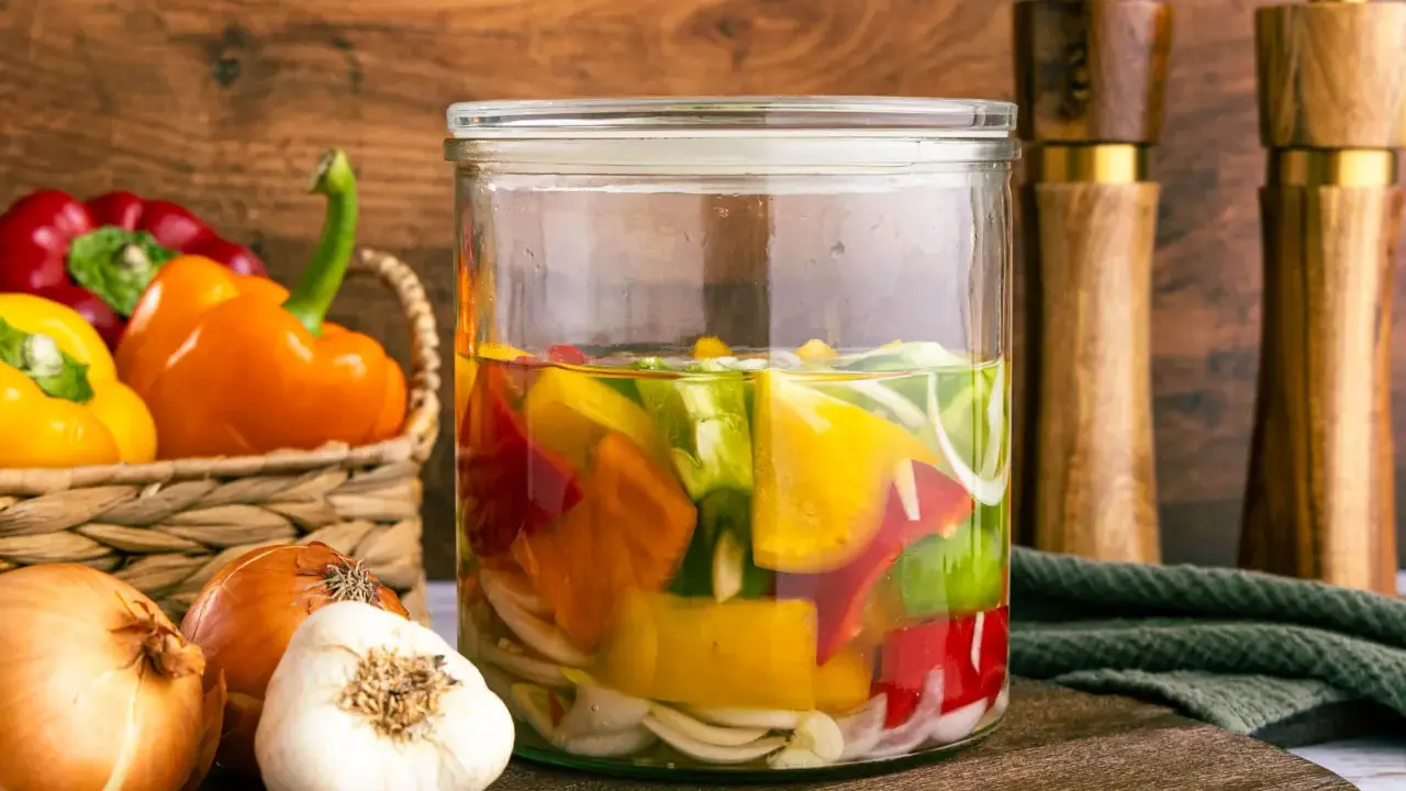 Buntes eingelegtes Gemüse im Glas: Paprika zum Abnehmen, Zwiebeln und Knoblauch.