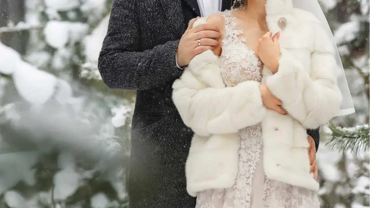 Para młoda w objęciach, otulona śniegiem i miłością. Romantyczne zimowe wesele w lesie.
