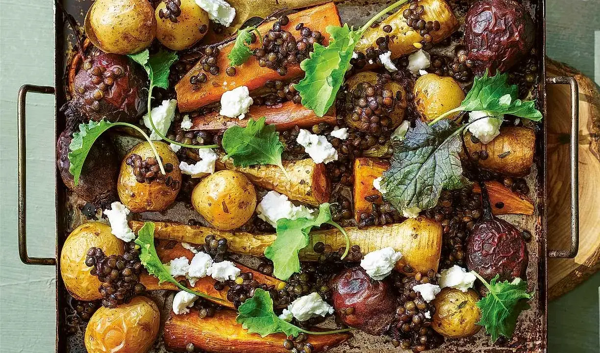 En ugnsrostad rotfruktslista med linser, fetaost och gröna blad. Perfekt för en höstig middag.