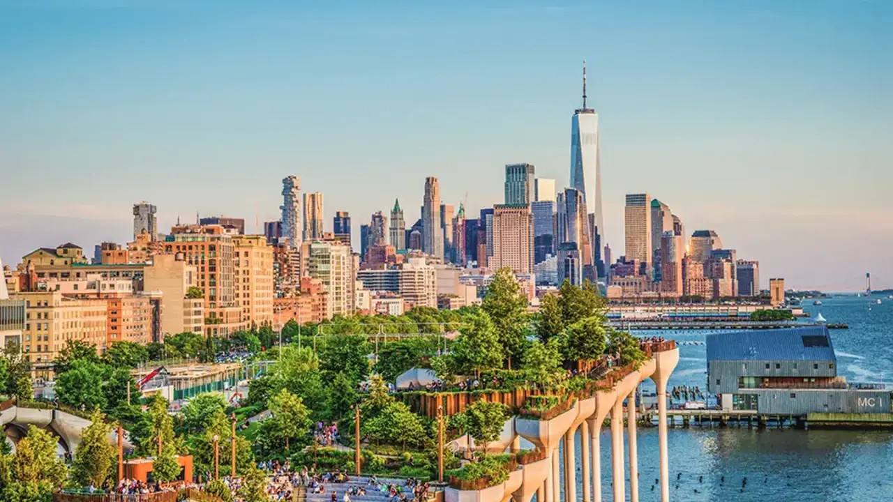 En grönskande park på pelare med New Yorks skyline i bakgrunden. Perfekt för tips på nya upplevelser i New York.