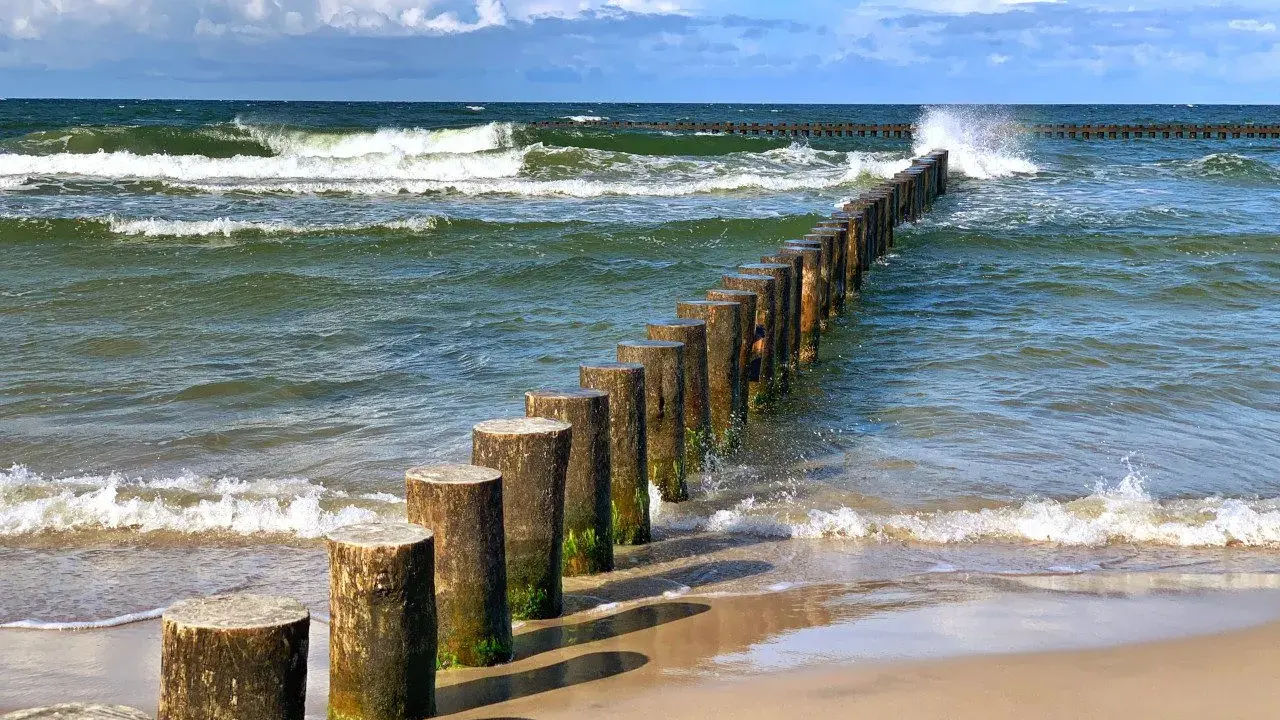 Jastrzębia Góra co zobaczyć: falochrony na plaży i wzburzone morze. Idealne miejsce na spacer i podziwianie Bałtyku.