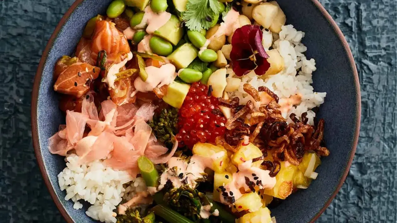 Eine bunte Poke Bowl mit Lachs, Avocado, Edamame, Reis, eingelegtem Ingwer und knusprigen Zwiebeln.