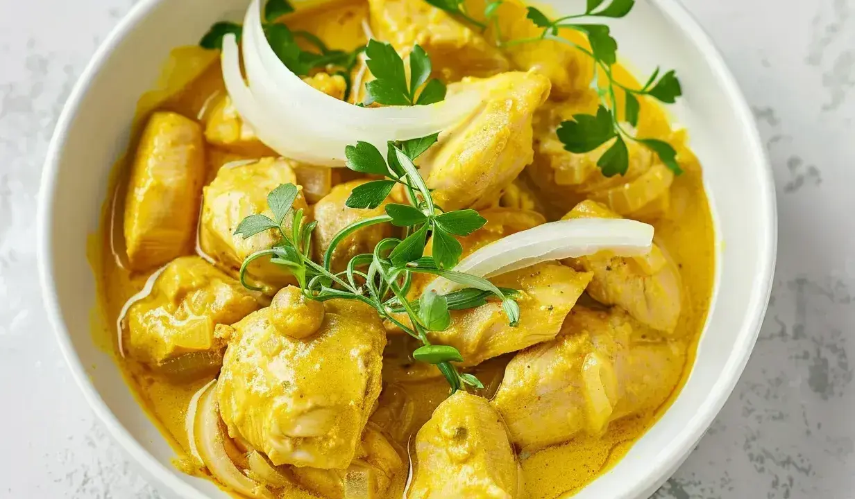 Kyckling i krämig currysås, perfekt för ett snabbt currysås recept. Garnerad med lök och persilja.