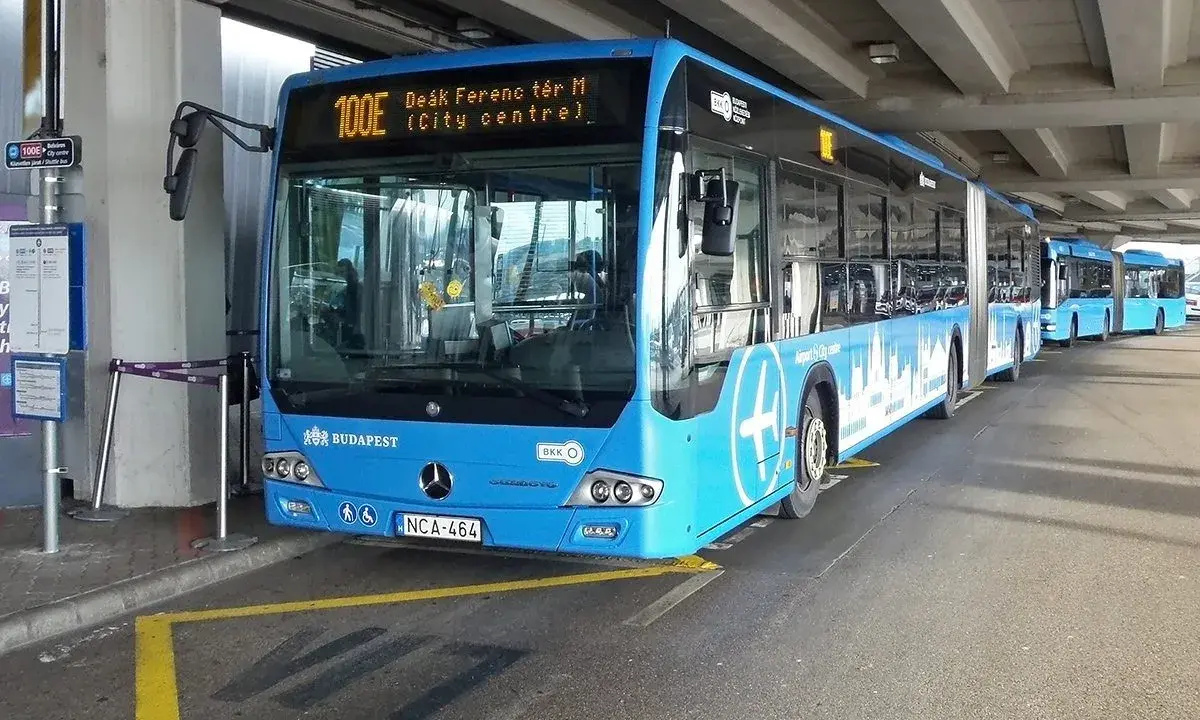Blå buss 100E vid Budapest flygplats, redo att ta passagerare till centrum.