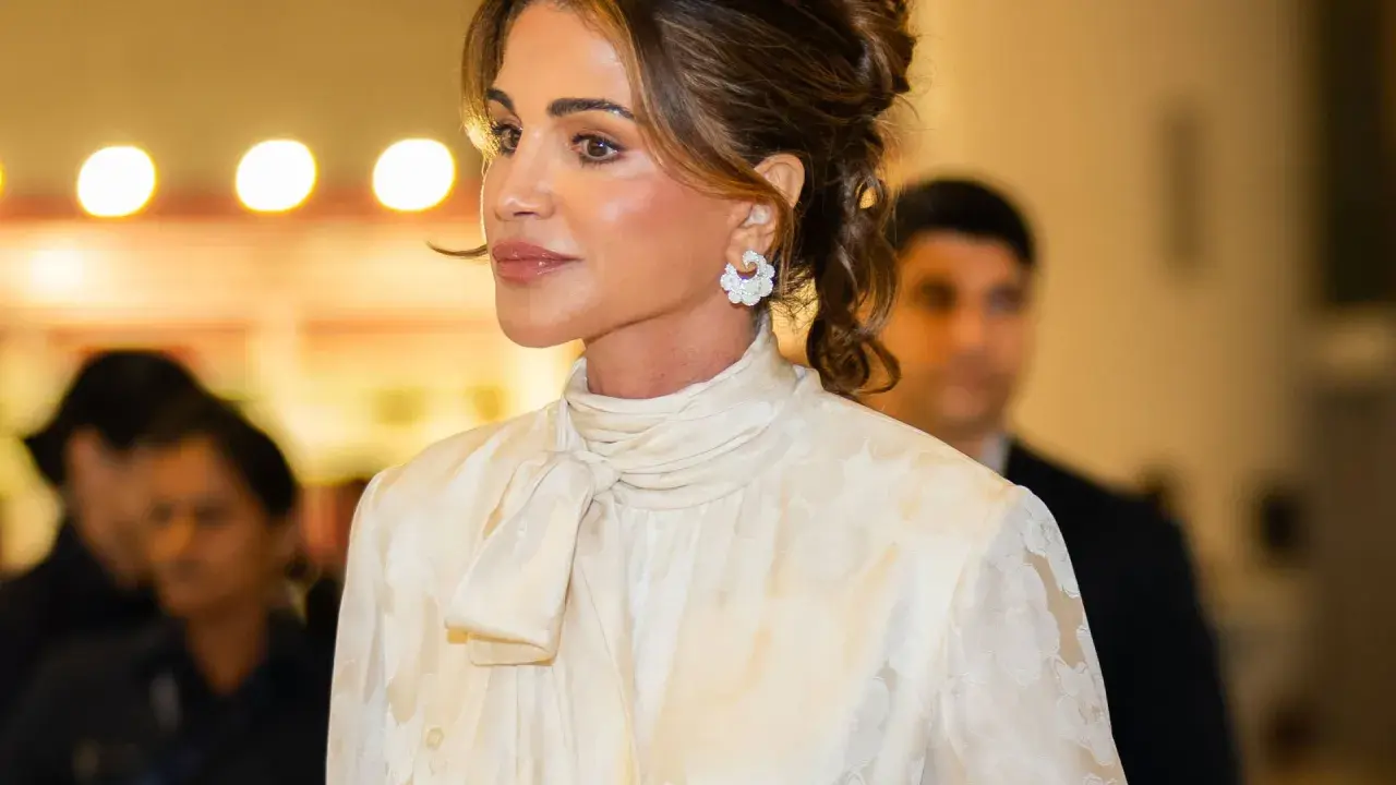 Queen Rania's elegant style shines in a cream, floral-patterned blouse with a chic pussy-bow.
