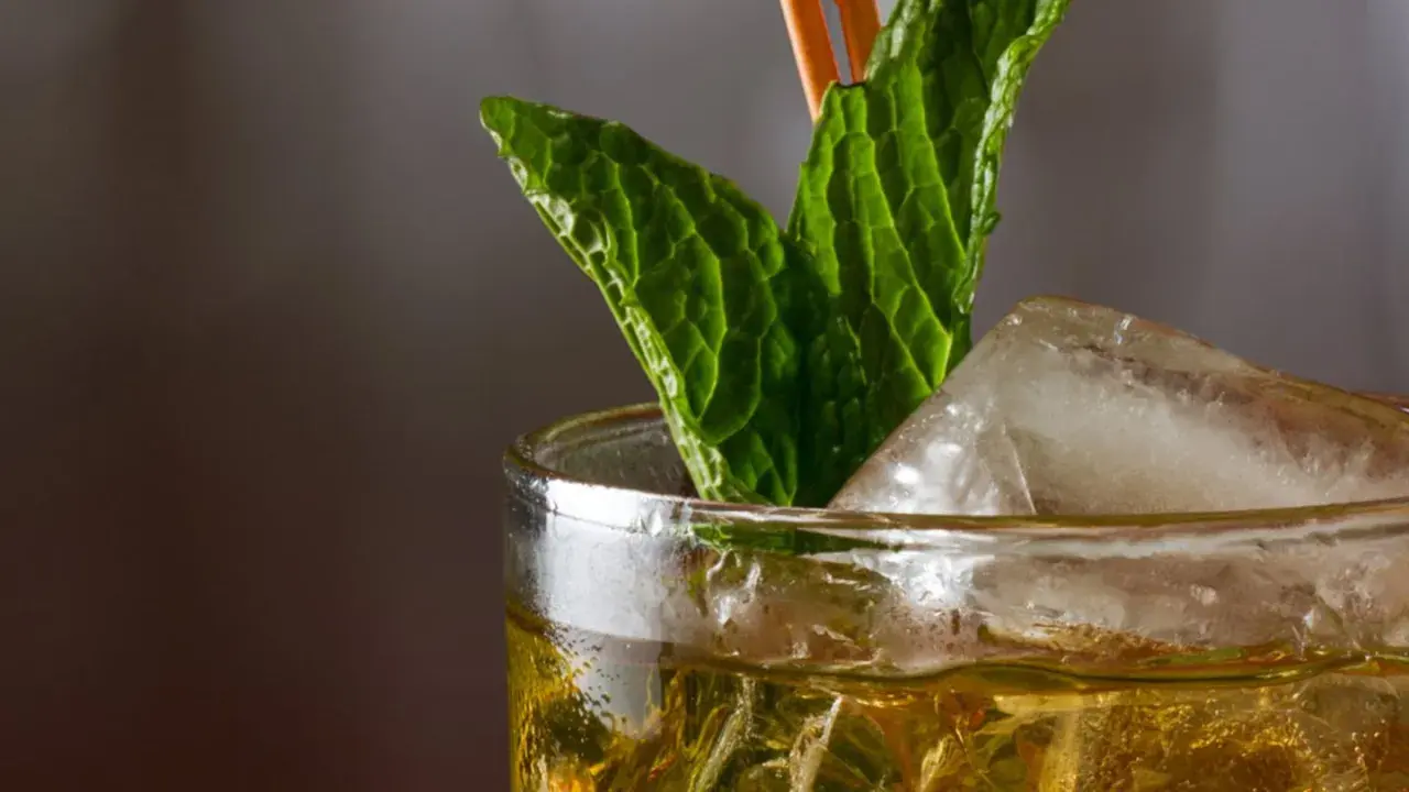 Ein erfrischender Mint Julep mit Eis und Minzblättern, bereit zum Genießen.