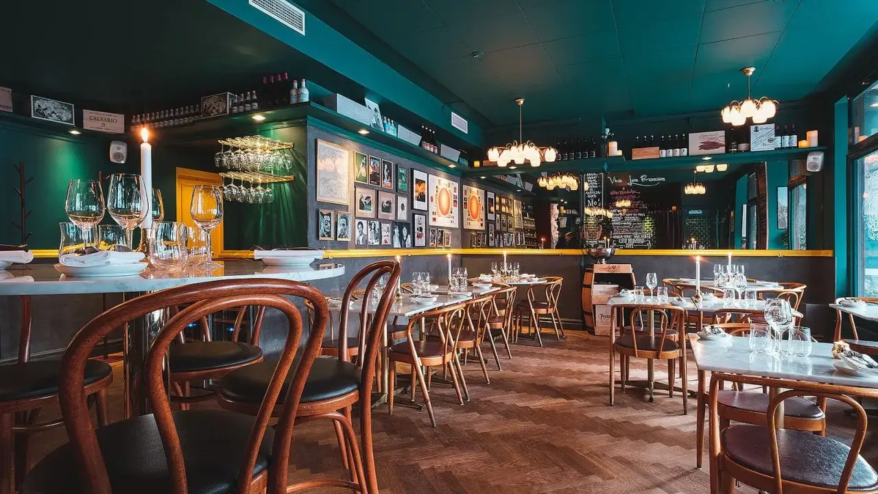 Mysig sydamerikansk restaurang i Stockholm med mörkt gröna väggar, trägolv och dukade bord.