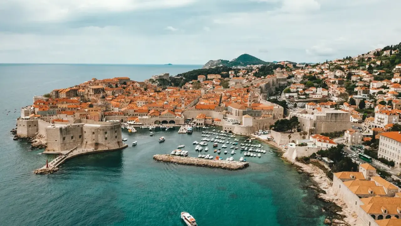 Aerial view of Dubrovnik's historic walled city and harbor, a beautiful destination for a gay vacation.