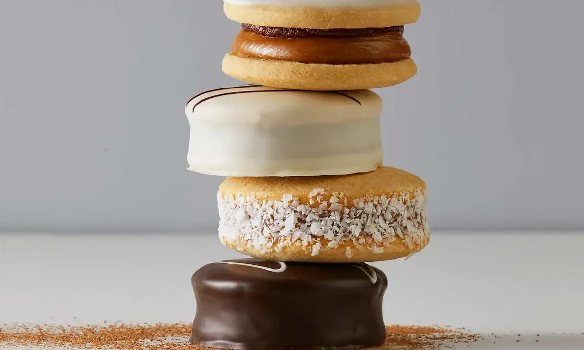 Una pila de alfajores, dulces típicos de Argentina y Uruguay, cubiertos de chocolate, coco y glaseado.