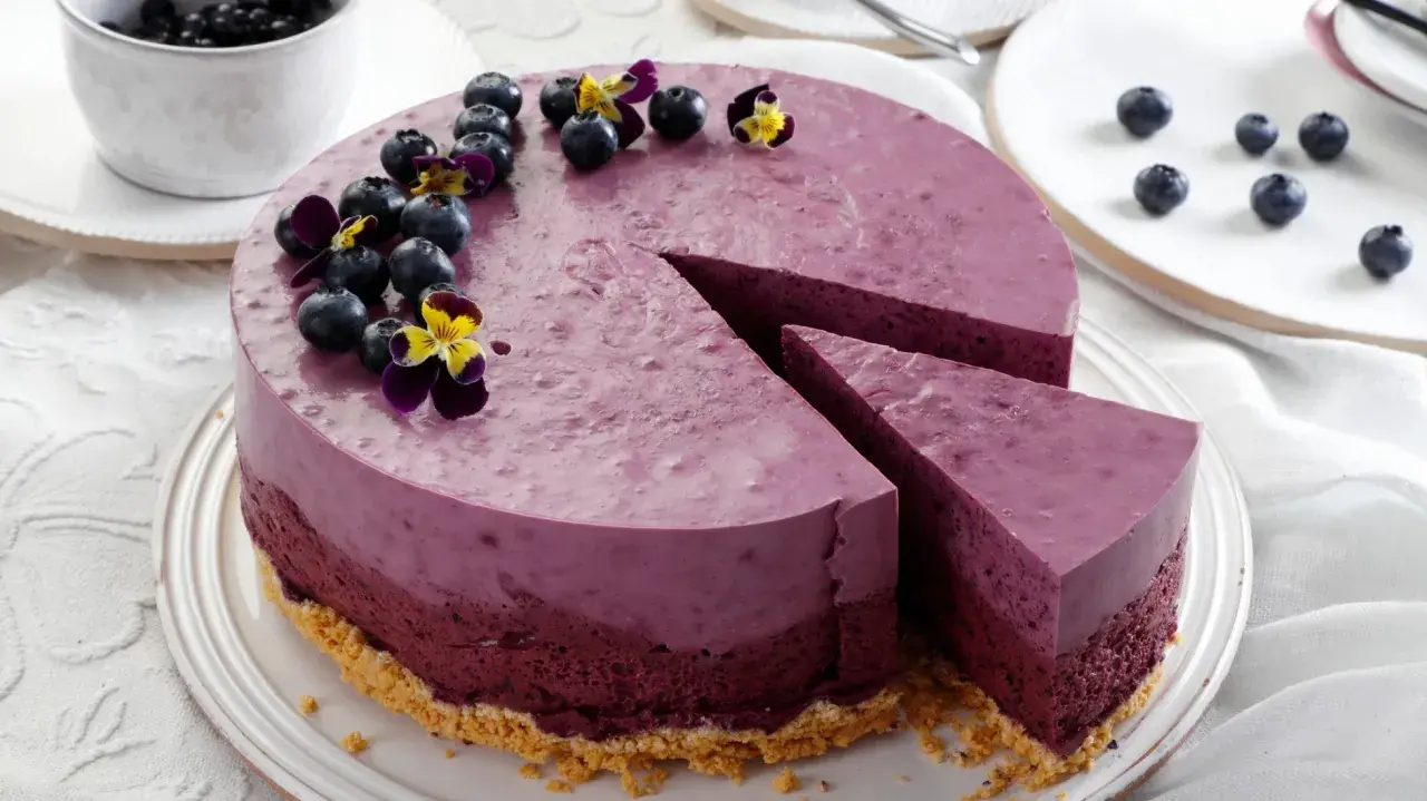 Ein wunderschöner Kuchen zum Muttertag, dekoriert mit frischen Blaubeeren und Veilchen.