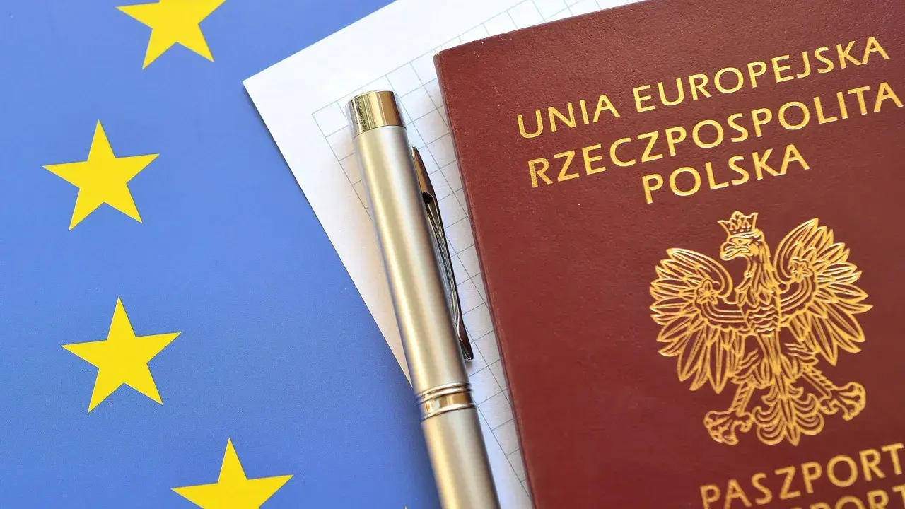 Polski paszport, długopis i flaga Unii Europejskiej.