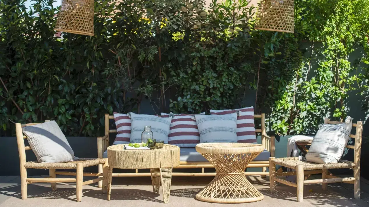 Un rincón acogedor para decorar terraza ático. Muebles de ratán, cojines y lámparas de mimbre crean un oasis natural.