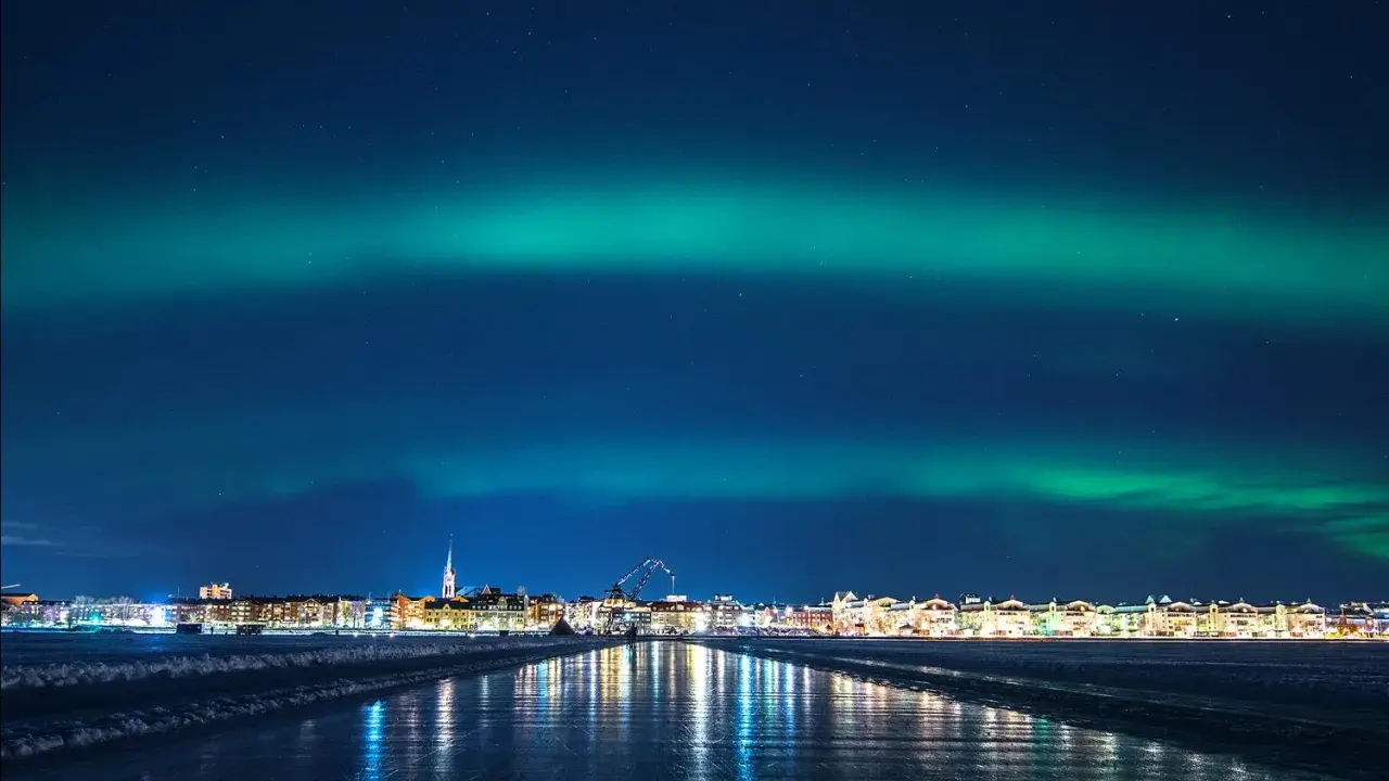 Norrsken över Luleå. En stad i ljus och en himmel målad i grönt.
