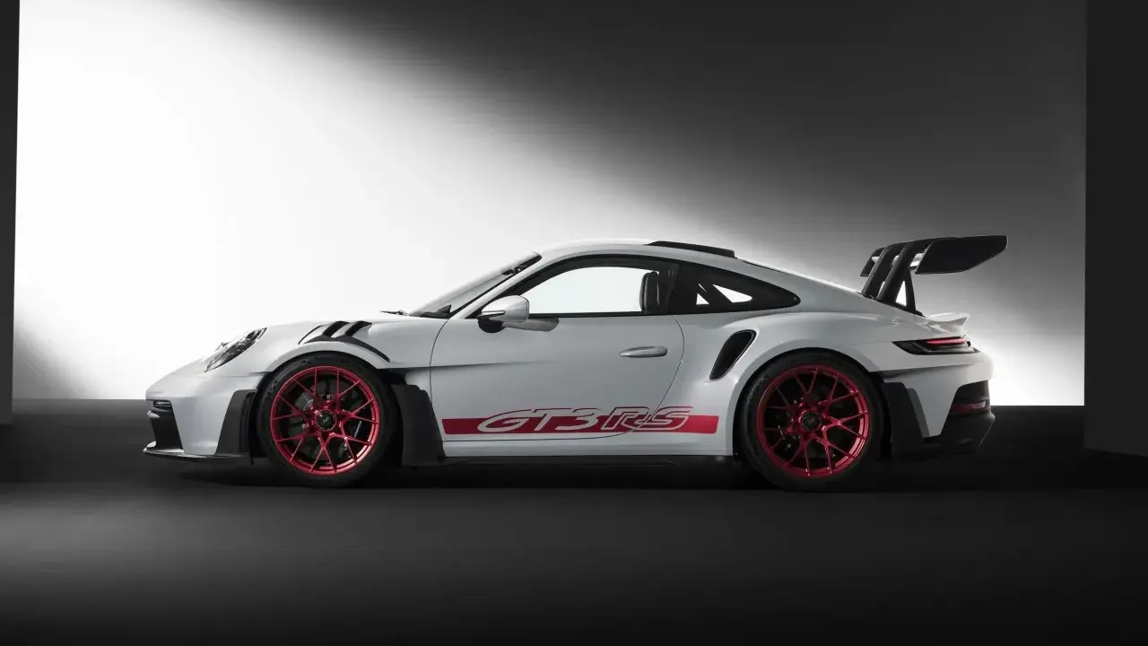 Weißer Porsche GT3 RS mit roten Felgen und Schriftzug. Ein Sportwagen, der Leistung und Eleganz vereint.