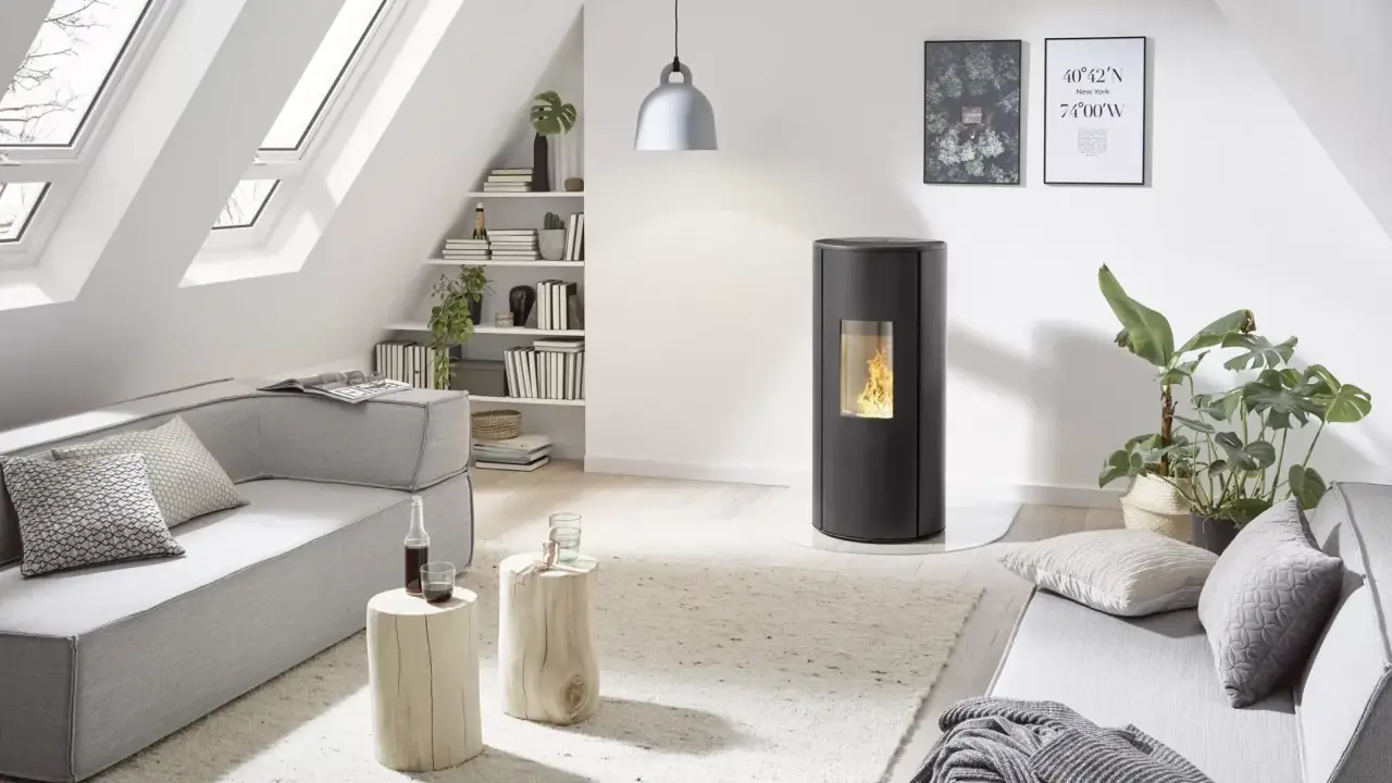 Poêle à granulés Rika en mode confort ou automatique, dans un salon moderne avec canapé gris, table basse en bois et lumière naturelle.