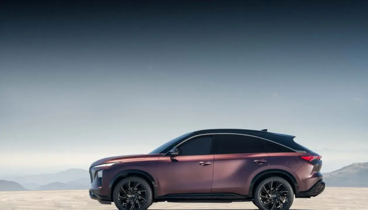 Eleganckie, bordowe infiniti auto z czarnym dachem na tle górskiego krajobrazu.