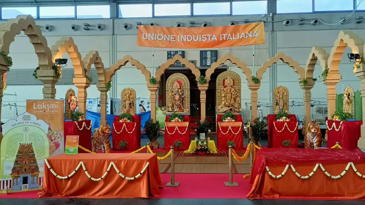 Allestimento per il festival dell'oriente Rimini con statue induiste, archi in legno e un grande striscione "Unione Induista Italiana".