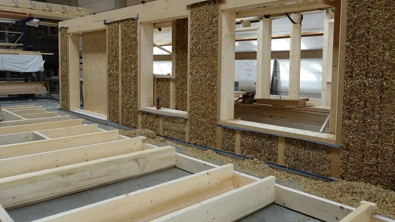 Holzkonstruktion mit Strohballenwänden im Bau. Die natürlichen holz eigenschaften machen es zu einem idealen Baustoff für nachhaltige Häuser.