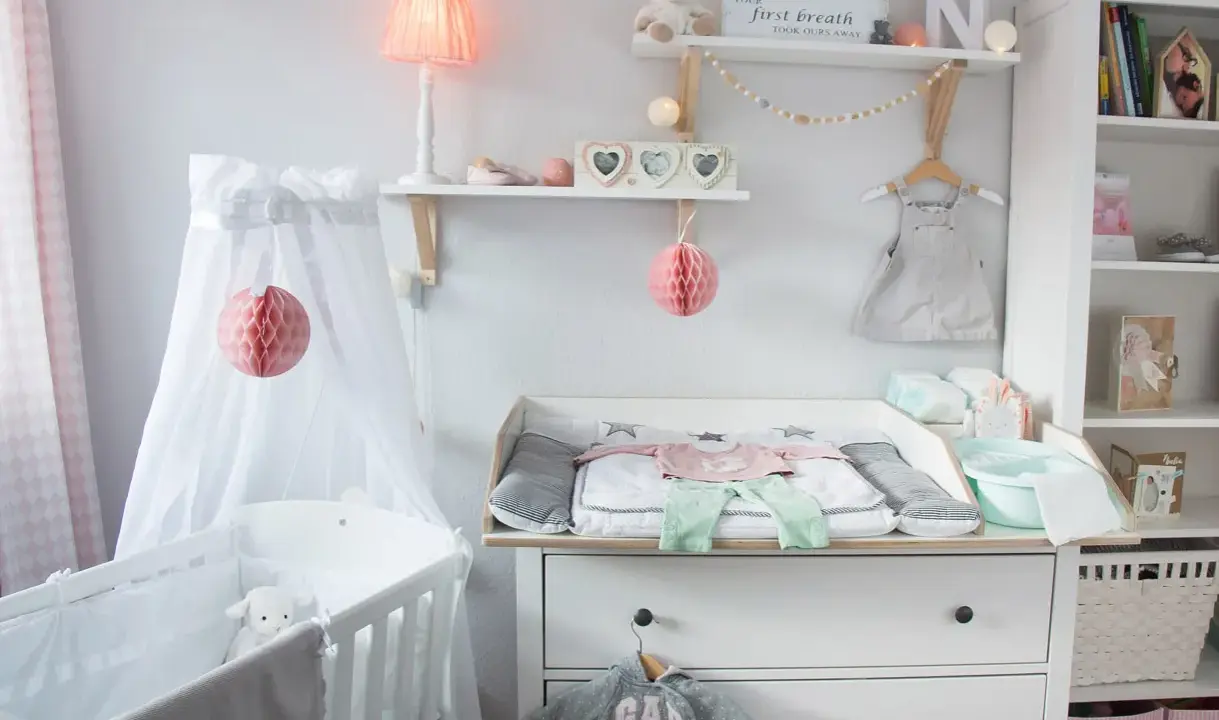 Eine liebevoll eingerichtete Hemnes Wickelkommode mit Babykleidung, Spielzeug und Deko.