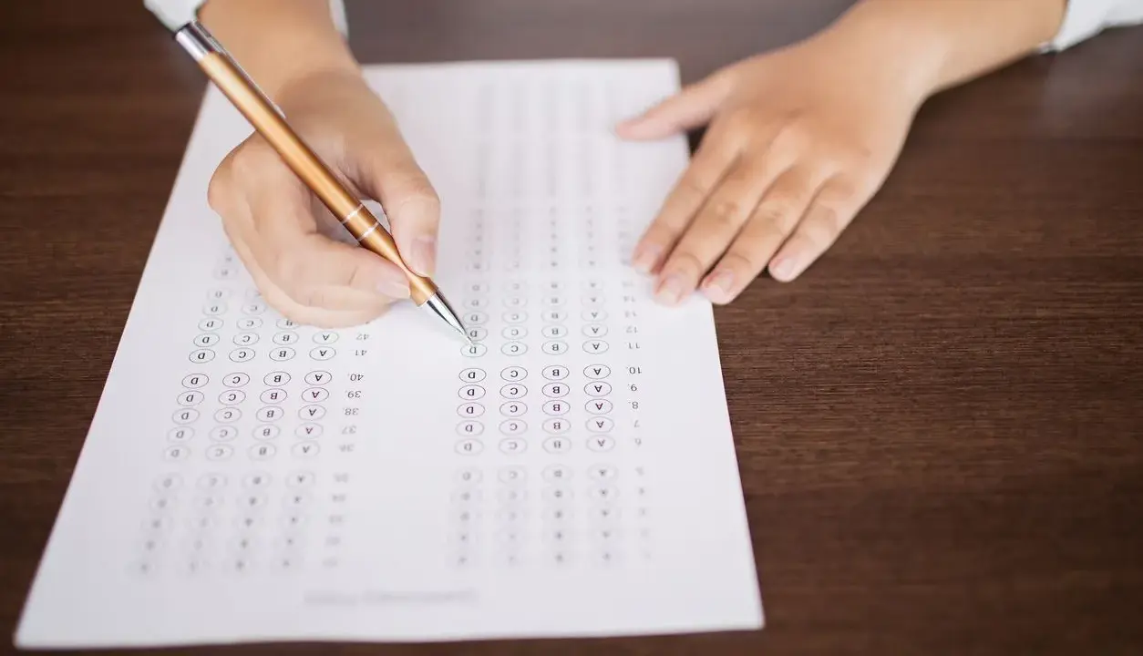 Persona completando un examen de opción múltiple, preparándose para el teórico carnet C.