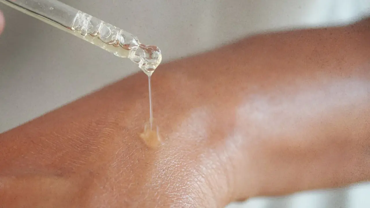 Kropla serum z niacynamidem 5% spada na skórę, nawilżając ją i odżywiając.