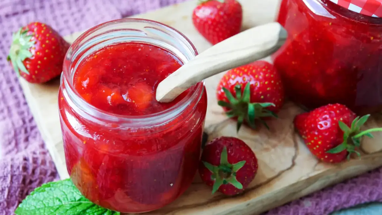 Frische Erdbeeren und selbstgemachte Marmelade in einem Glas. Perfekt zum Marmelade einfrieren für den Winter.