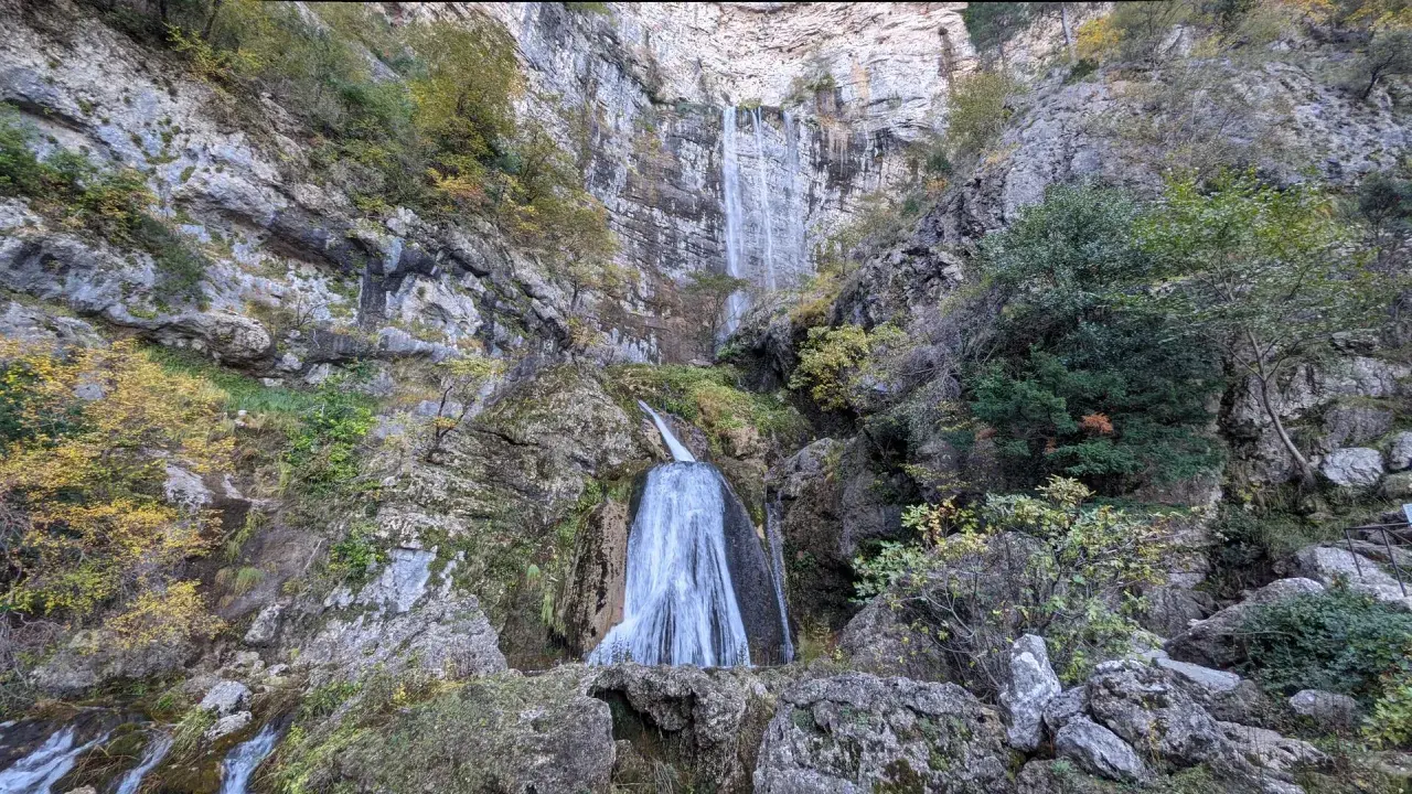 Impresionante cascada en la ruta de las cascadas Bogarra, cayendo por una pared rocosa con vegetación otoñal.
