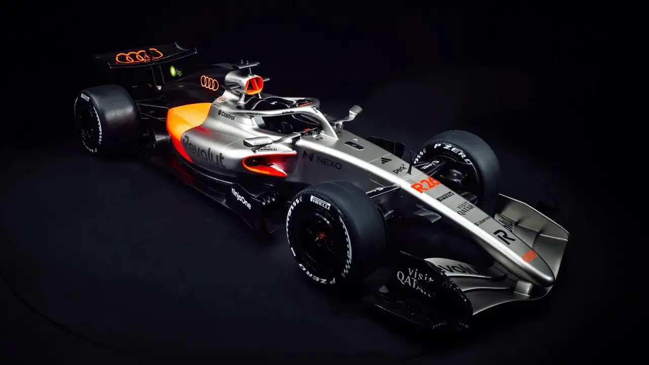 Ein silberner und oranger Audi F1 Auto mit dem Audi-Logo auf dem Heckflügel.