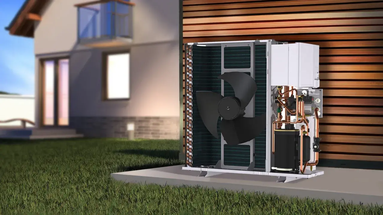 Unidad exterior de bomba de calor para hidrotermia en casa, con ventilador y tuberías de cobre visibles, junto a una casa moderna.