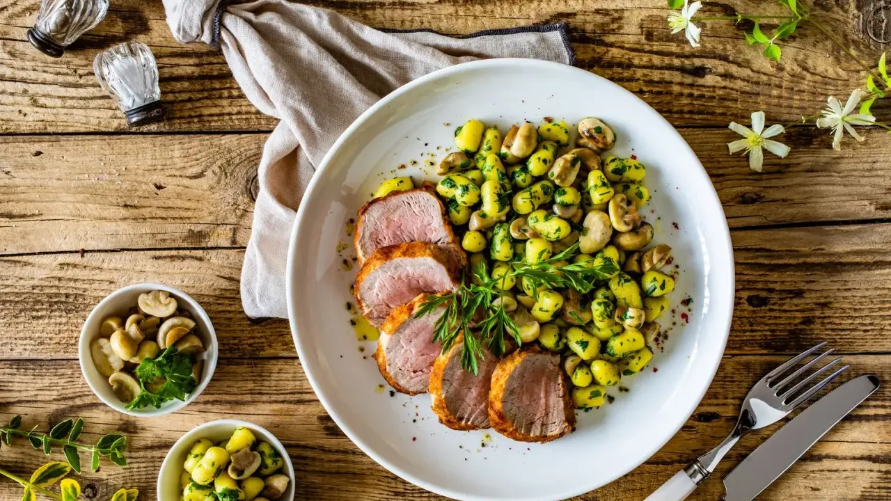 Saftige schweinelende grillen, serviert mit Kartoffeln und Pilzen, garniert mit frischer Petersilie. Ein Genuss für jeden Grillmeister!
