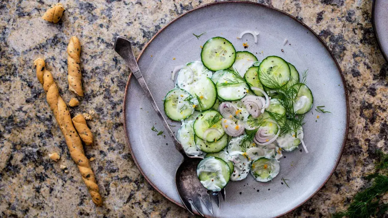Salade de concombre crémeuse, parfaite pour une recette légère. Des rondelles fines de concombre, oignon rouge, aneth frais et une sauce onctueuse.