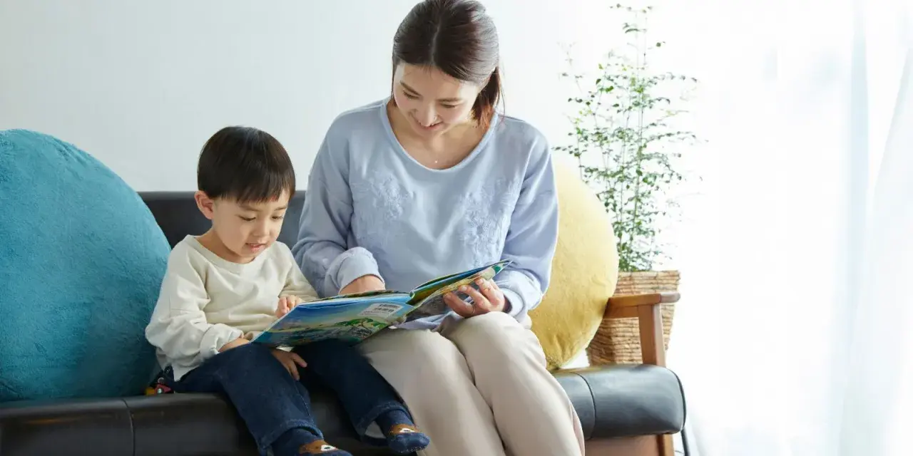 Madre e hijo comparten un momento de lectura, aprendiendo juntos. Las frases de disciplina pueden ser parte de las lecciones de vida que se transmiten.