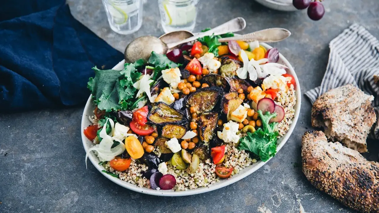 En härlig bowl med quinoa, kikärtor, tomater, fetaost och härligt grillad aubergine. Serveras med gott bröd och vatten med citron.