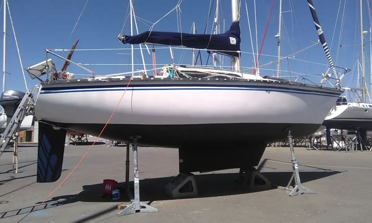Voilier Kelt 850 blanc et gris, sur bers, prêt pour l'hivernage.
