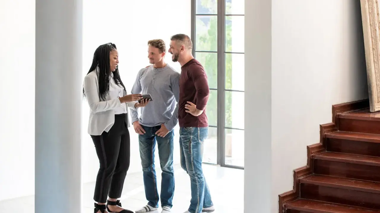 Un agent immobilier montre un appartement à un couple. La question se pose : peut-on louer un appartement seul quand on est marié ?